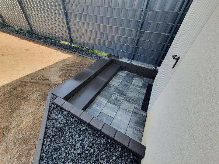 Gartentreppe aus massiven Blockstufen und Plattenbelag mit seitlichem Kiesstreifen