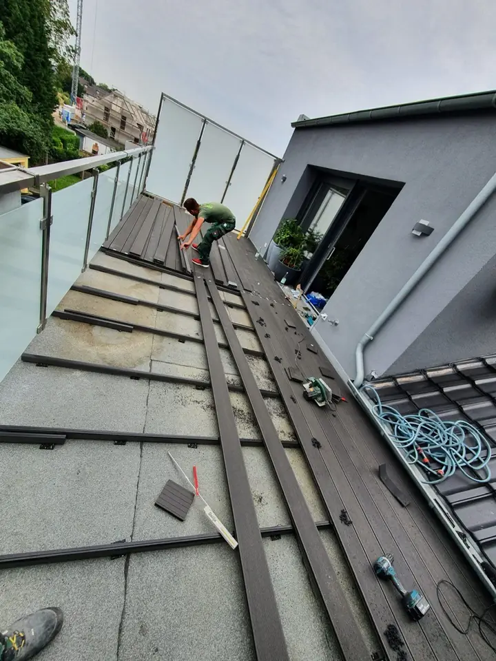 Witterungsbeständige Holzterrasse mit stilvollem Glasgeländer und solidem Unterbau