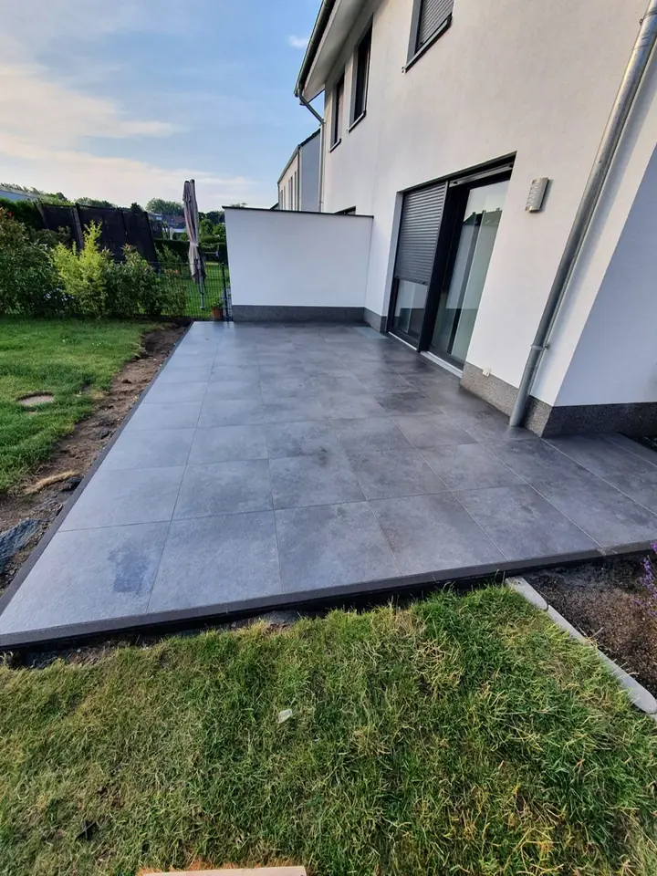 Terrassenbelag in moderner Betonoptik mit sauber angearbeiteter Rasenkante