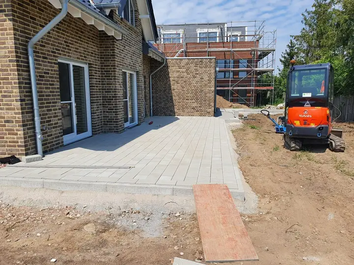 Heller Terrassenplattenbelag während der Außenanlagengestaltung mit Minibagger