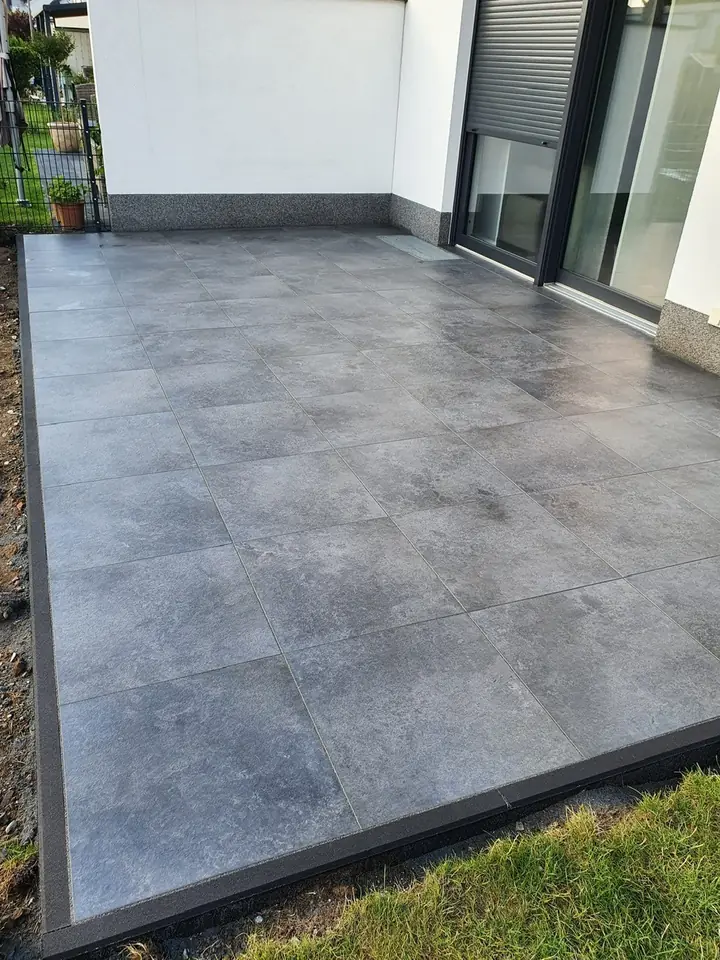 Moderne Terrassenplatten in Betonoptik mit nahtlosem Rasenabschluss