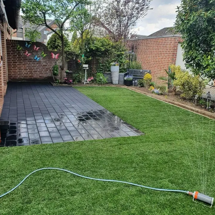 Neugestalteter Gartenbereich mit hochwertiger Pflasterung und Rasenfläche
